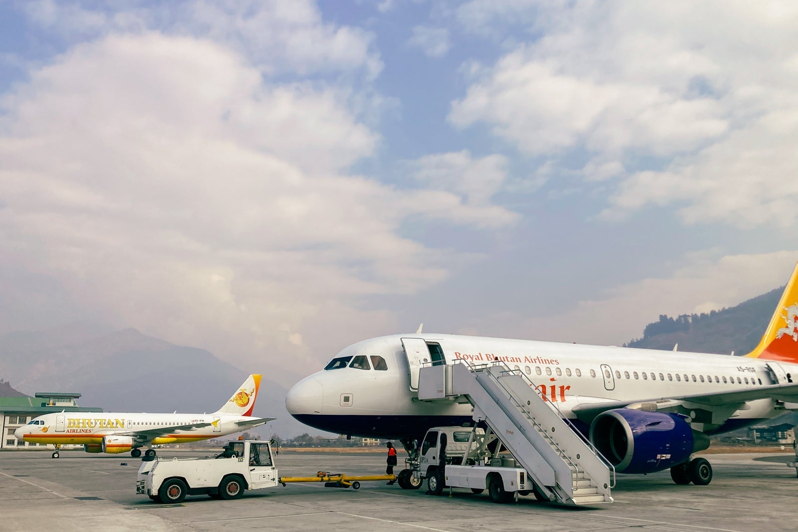 2 airplanes sit on the tarmac at Paro International Airport in Bhutan