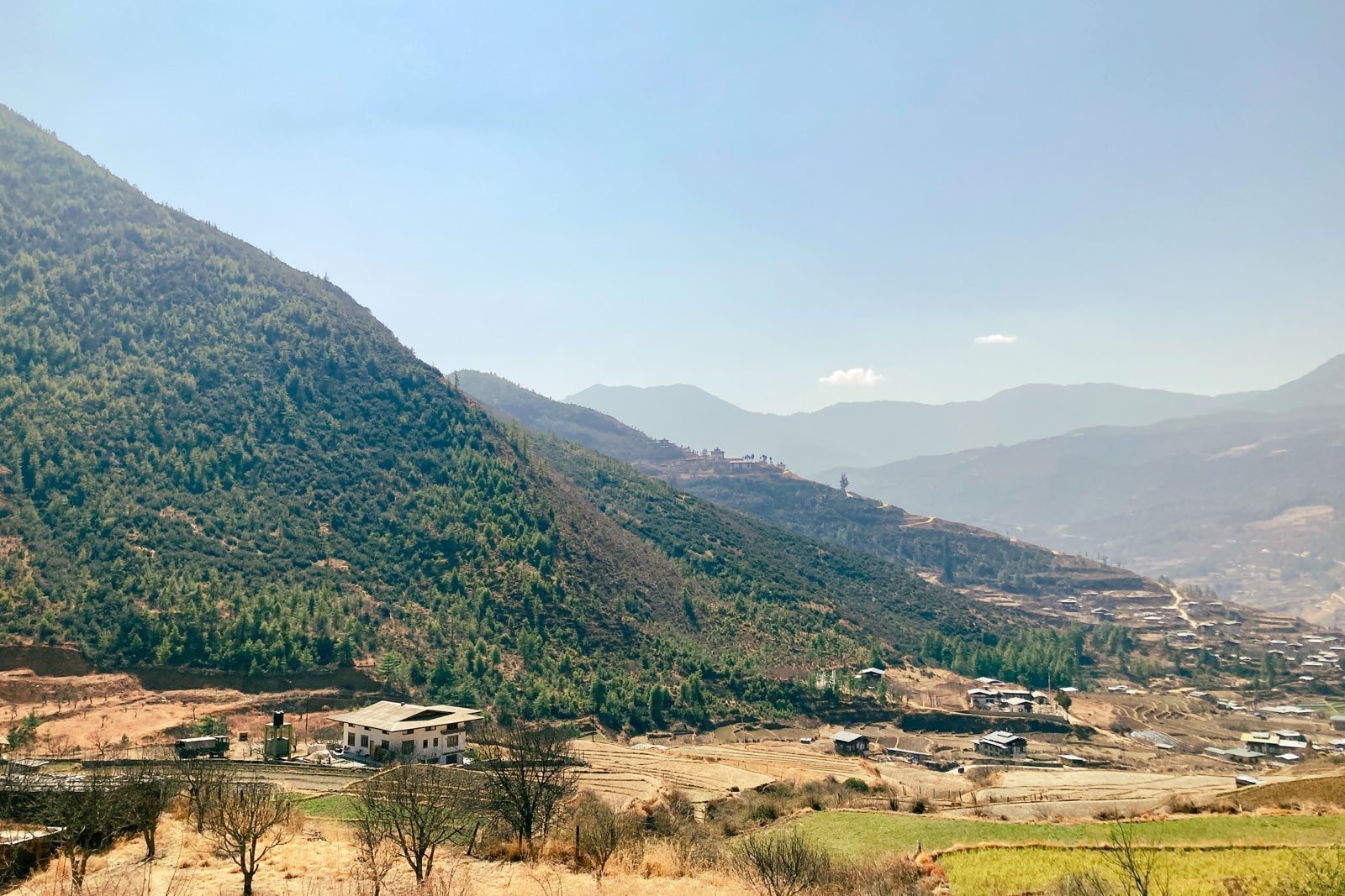 small houses among hills covered with grass and trees