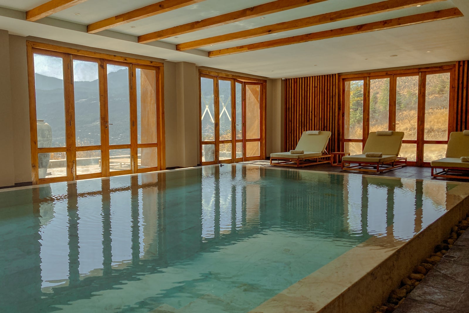 an indoor infinity pool surrounded by floor-to-ceiling windows in a luxury hotel