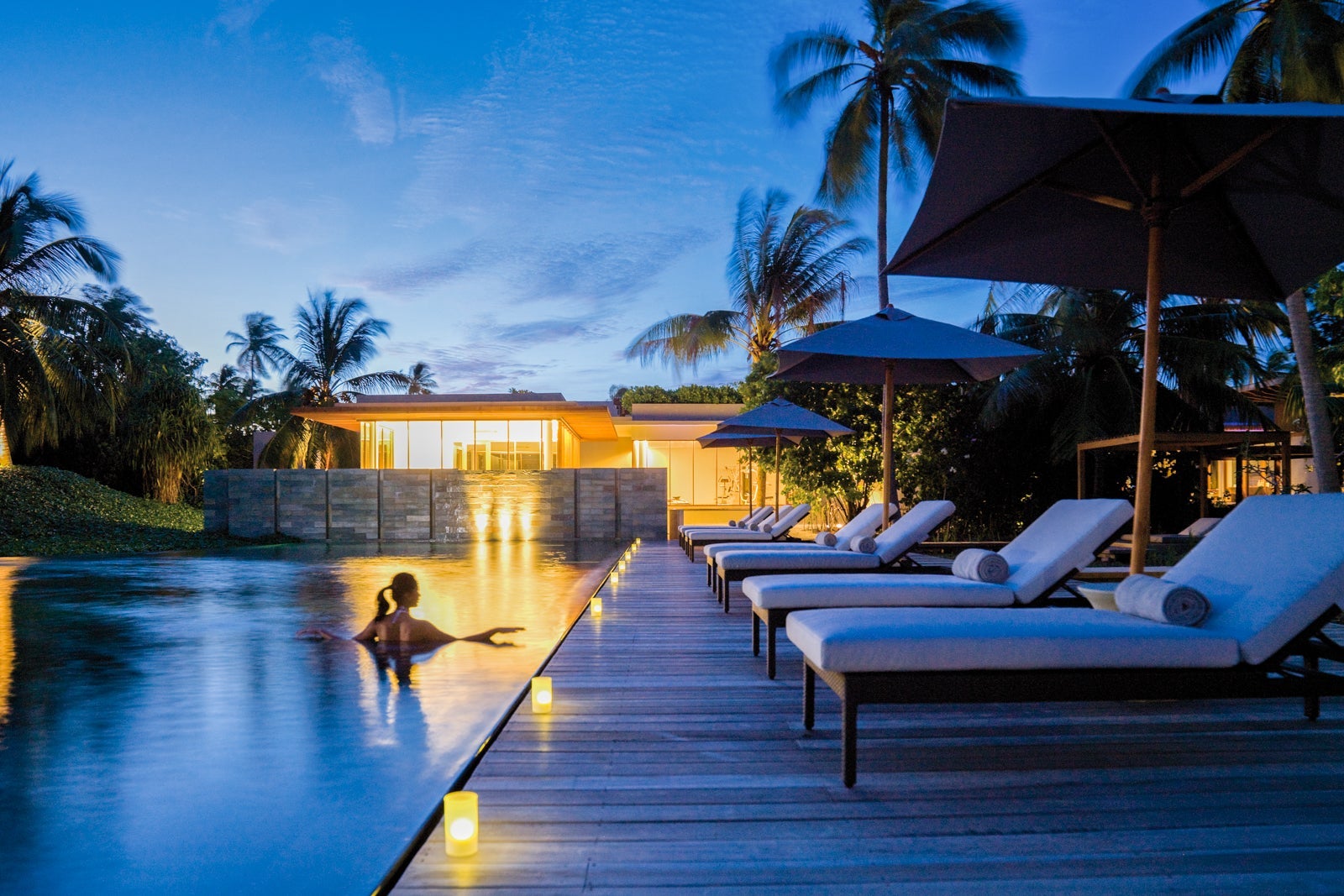 woman in pool at dusk at Park Hyatt Maldives Hadahaa