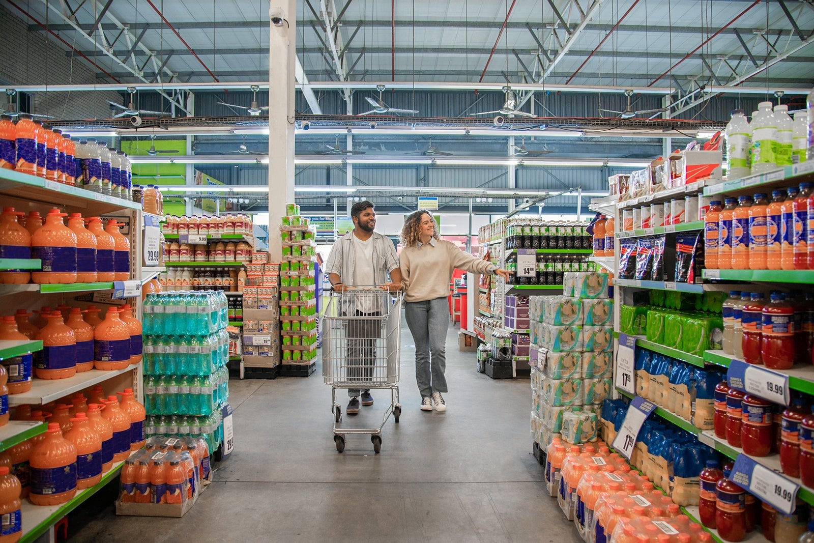 Two people walking through a supermarket