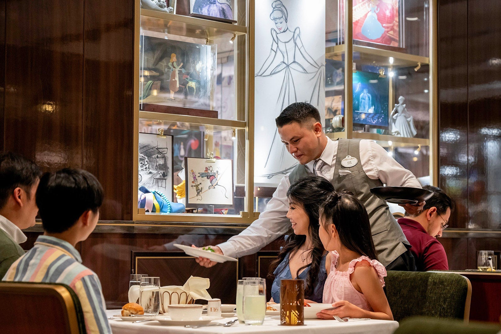 A waiter serves a family in one of the dining rooms on a cruise ship