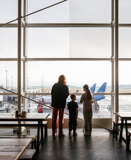 people looking out window airport