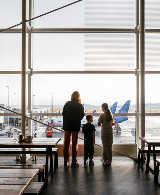 people looking out window airport