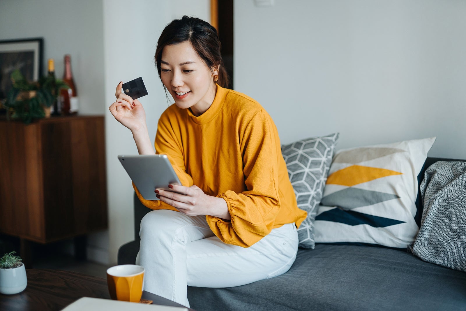 Woman using a tablet with a credit card