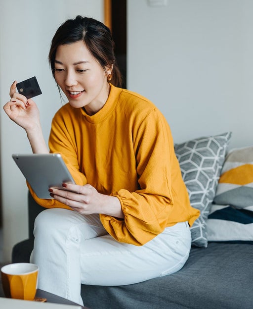 Woman using a tablet with a credit card