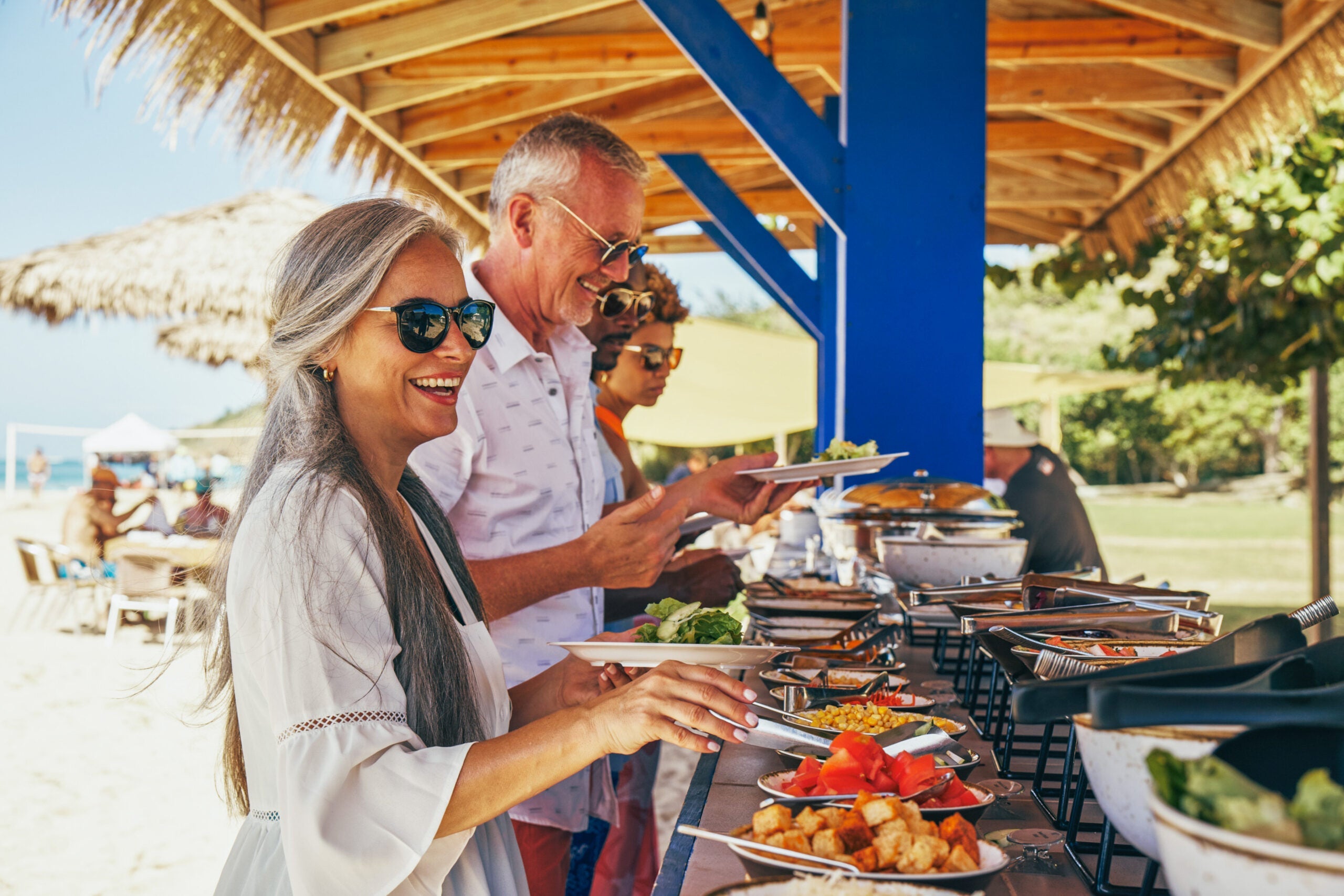 Cruise passengers in line at a buffet on the beach during a Windstar Cruises voyage