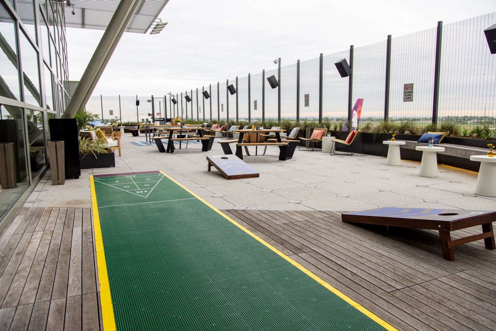 an outdoor terrace showing shuffleboard and cornhole (beanbag toss) games