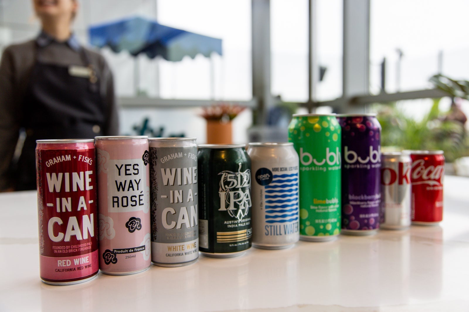 multiple beer cans line a counter at a bar