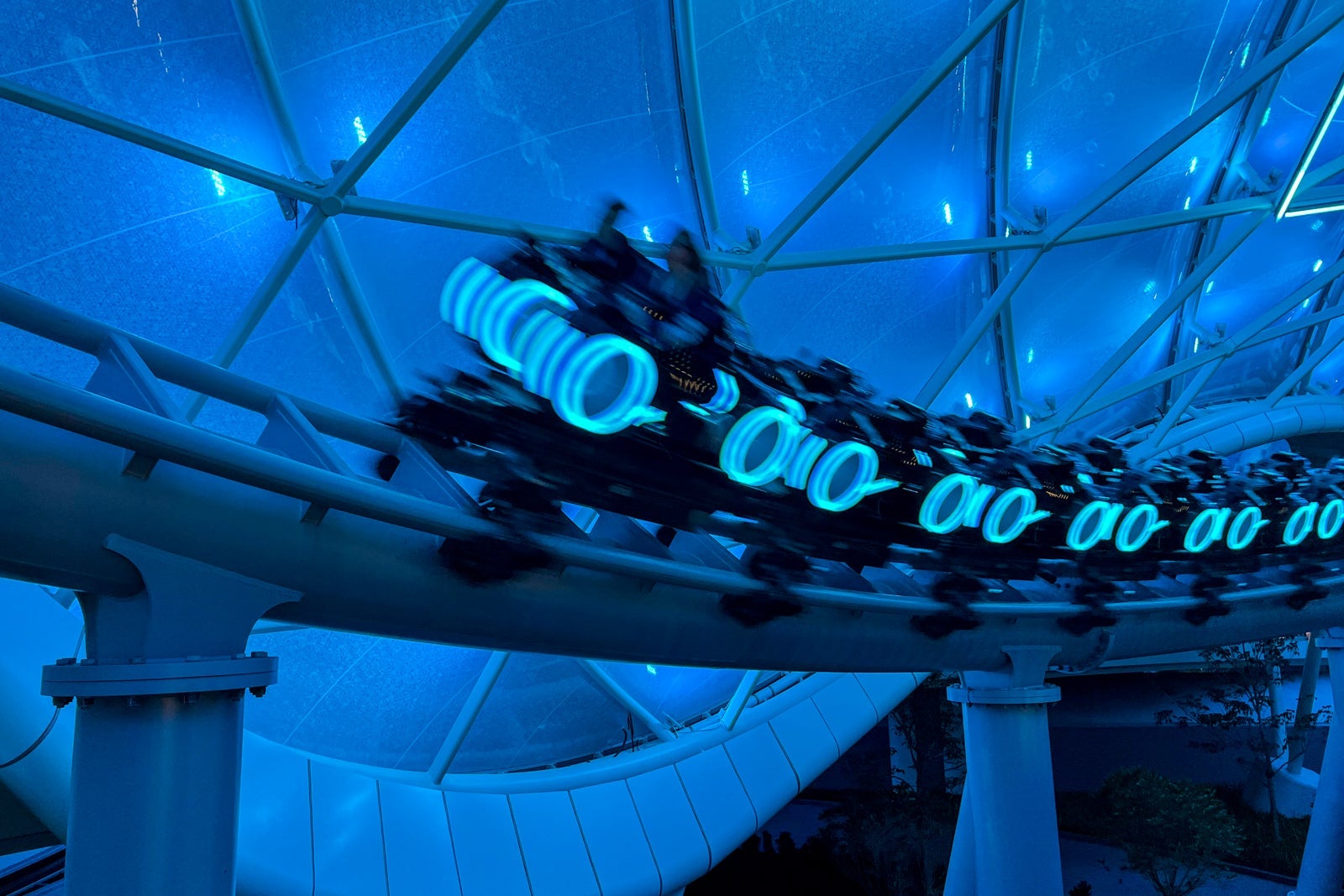 Ridecars zooming by for Tron Lightcycle Run