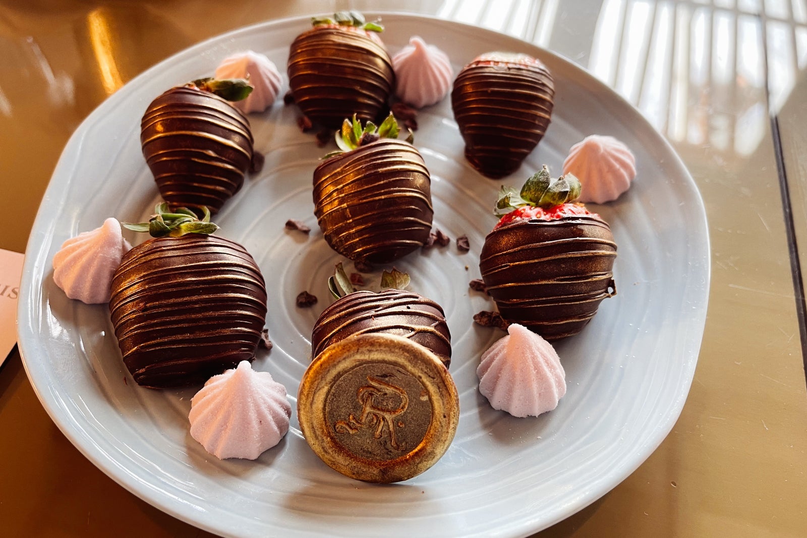 a platter of chocolate-covered strawberries with a gold "R" emblem signifying The St. Regis Punta Mit