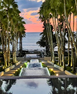 reflecting pool and palm trees overlooking ocean at sunset at St. Regis Punta Mita