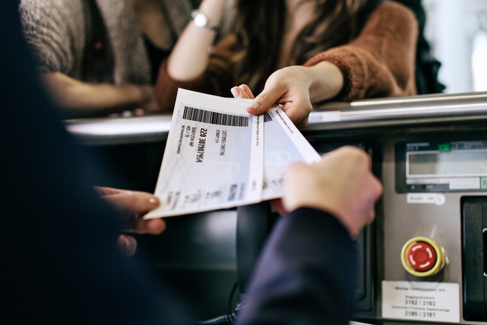 Travelers handing boarding passes to gate agent