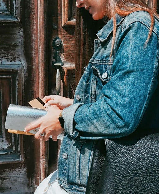 a woman holds a wallet with many credit cards