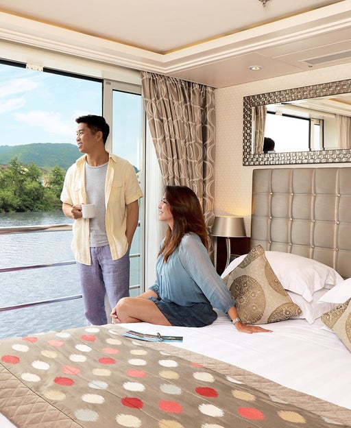 Couple in river cruise cabin with balcony door open