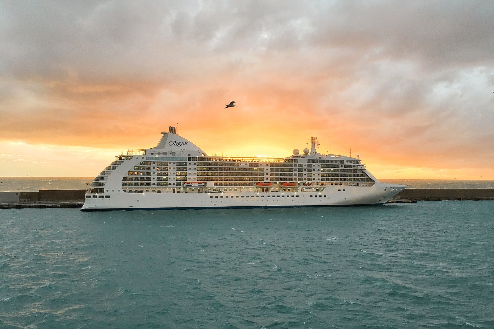 Seven Seas Mariner luxury cruise ship docked at sunset