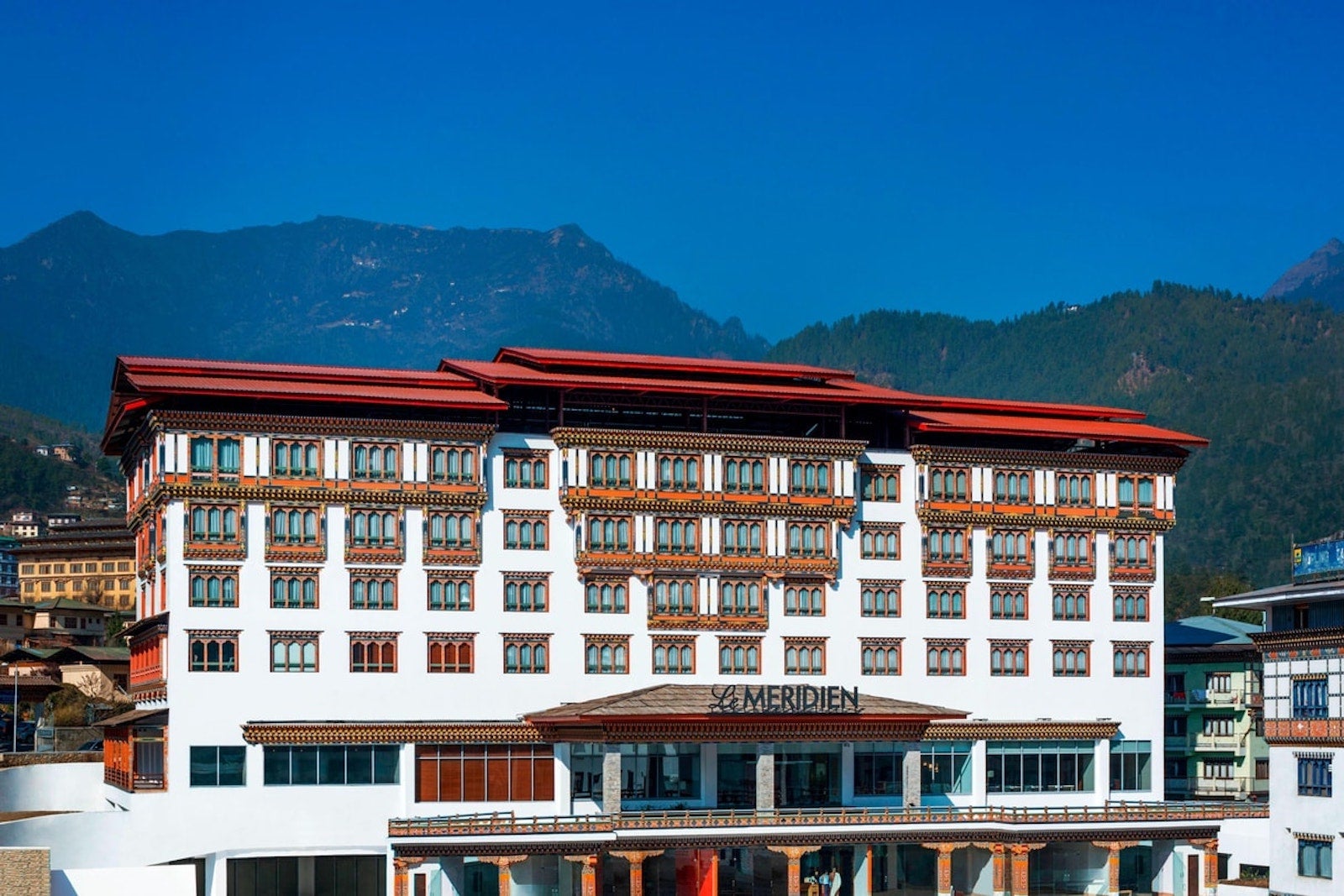 a multi-story hotel with a Le Meridien sign but built in traditional Bhutanese style