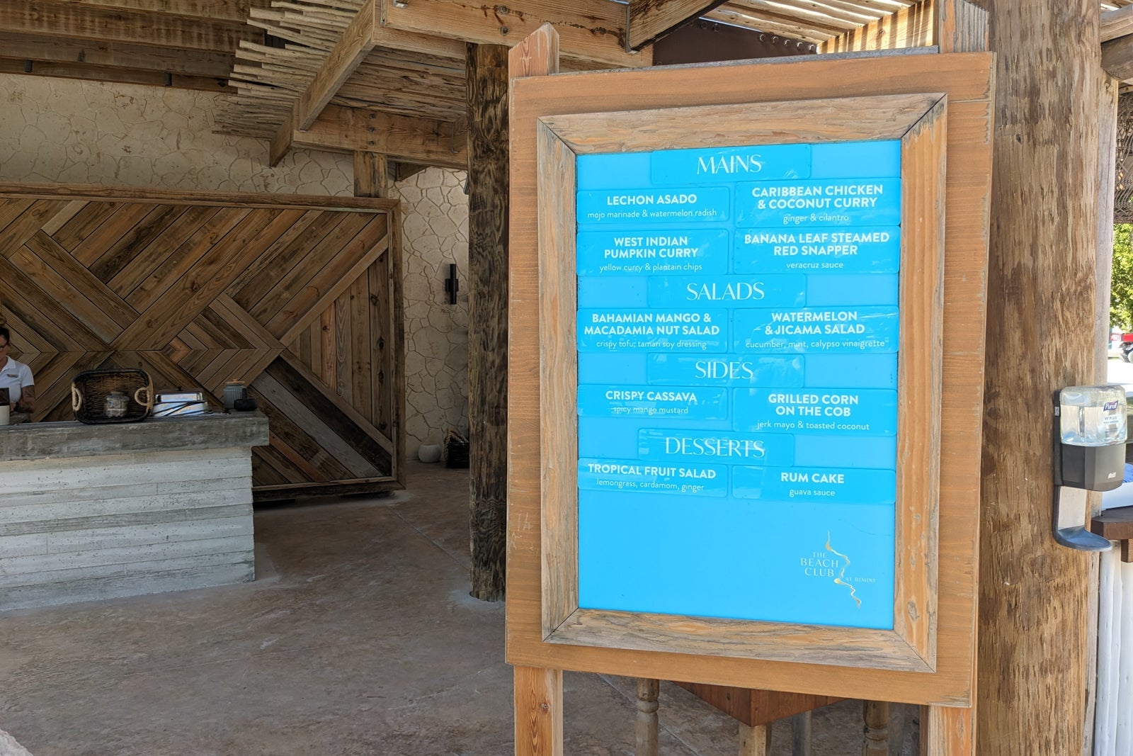 Blue sign listing beach club food menu