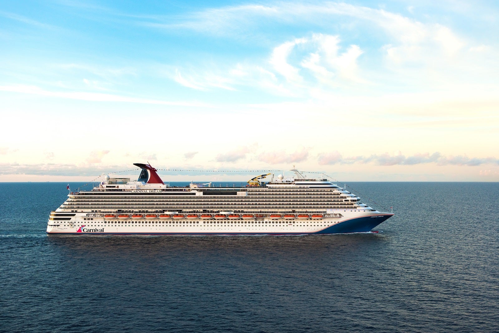 A cruise ship with a blue hull and red funnel anchored at sea