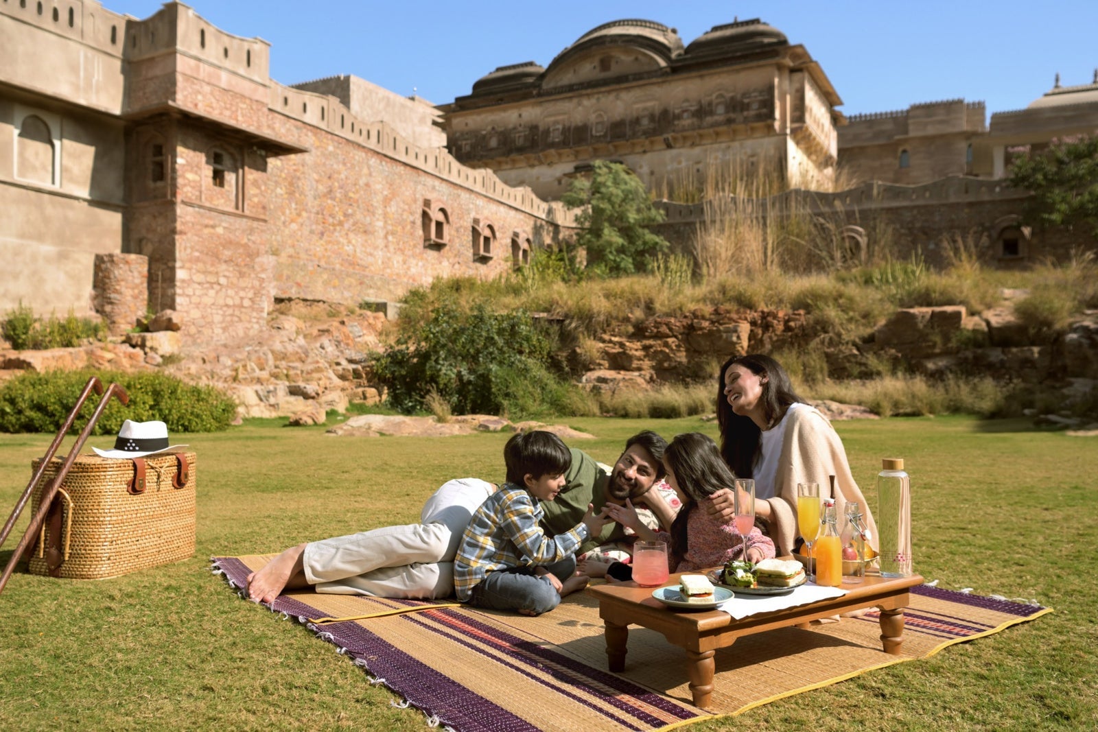 Family relaxing outside Six Senses Fort Barwara