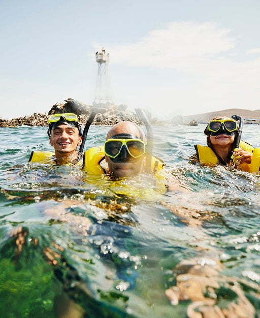Medium shot of smiling family on snorkeling tour in tropical ocean