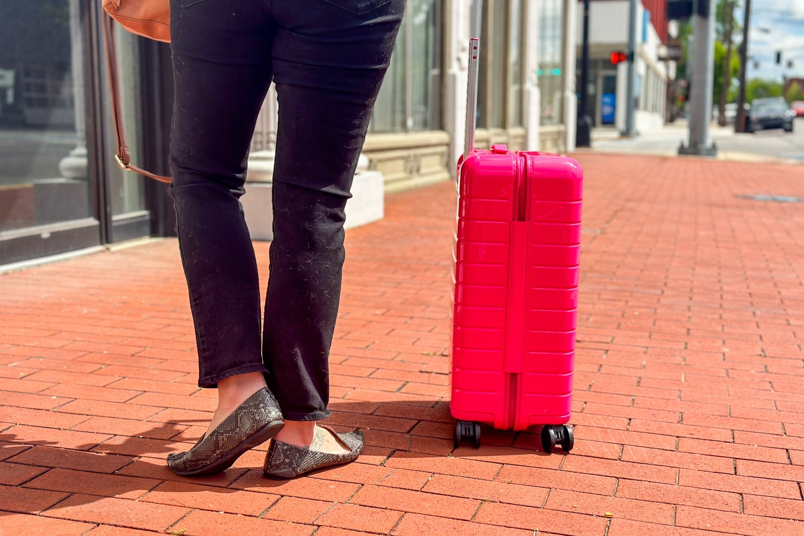 person rolling pink suitcase