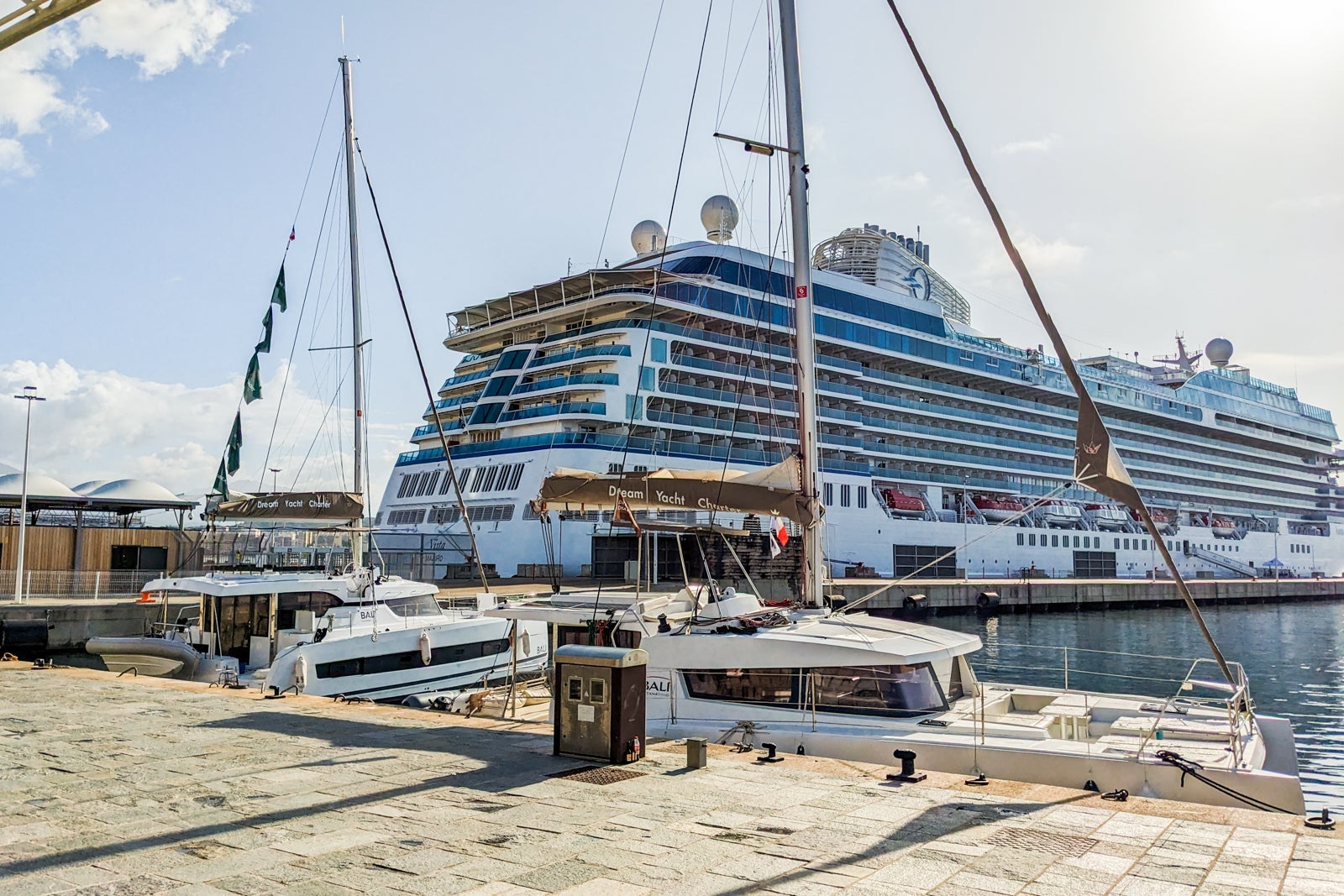 A shot of the rear starboard side of a white cruise ship that's docked
