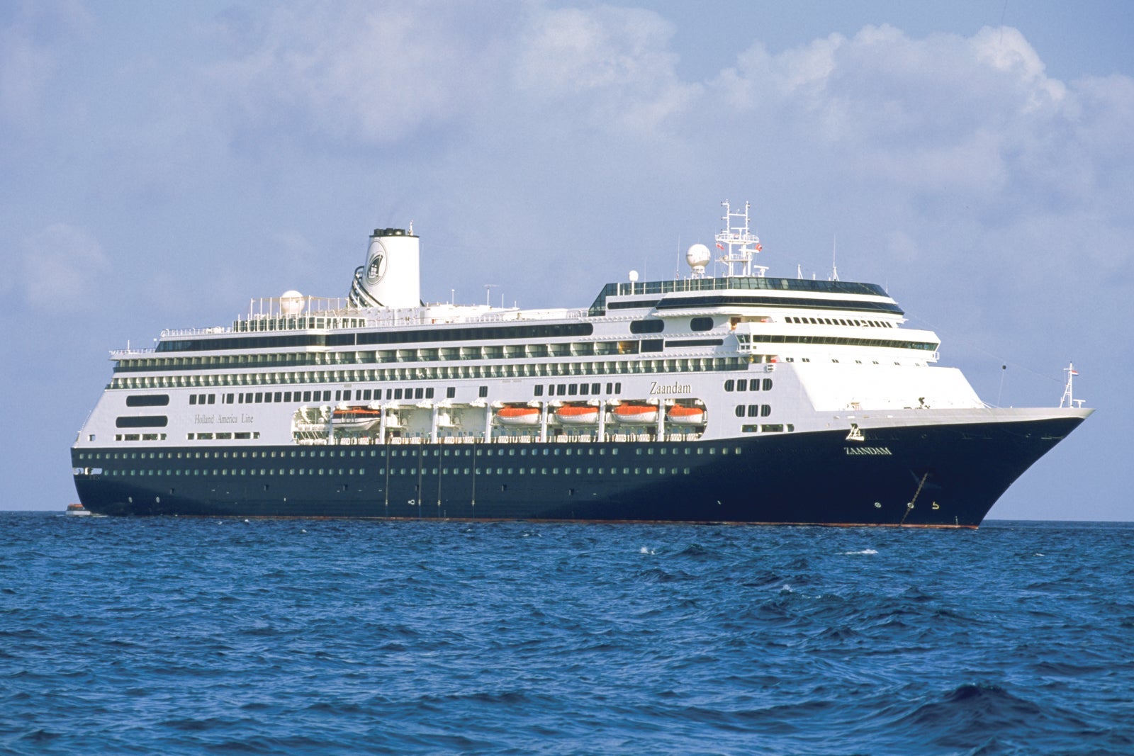 A Holland America cruise ship anchored on blue water