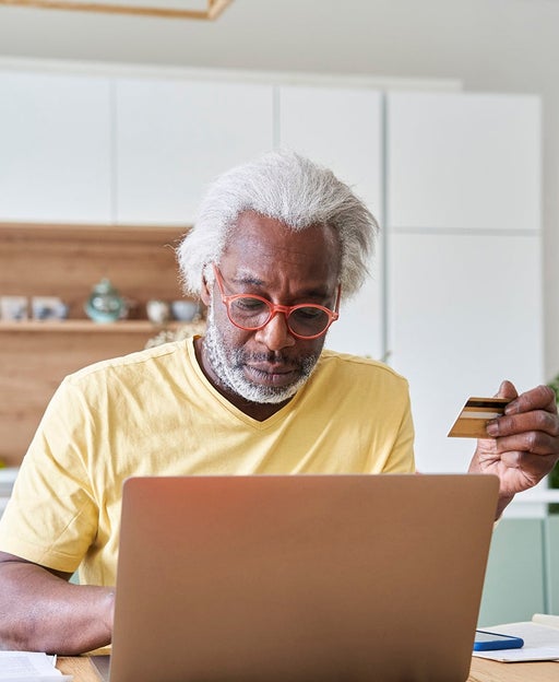 Senior man using laptop and credit card