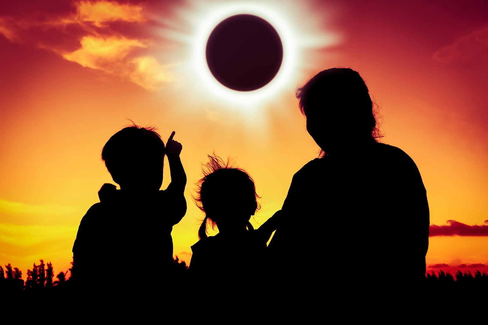 Silhouette of family watching solar eclipse