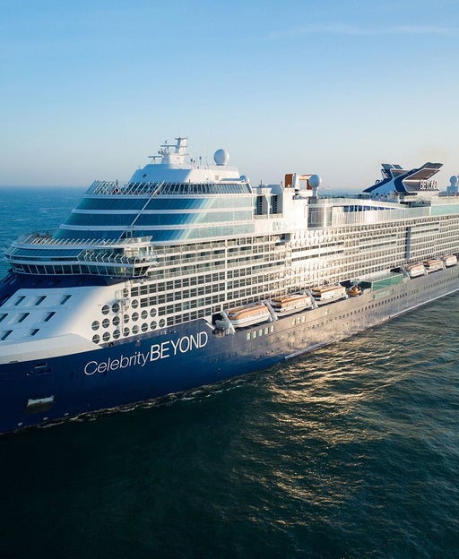 Celebrity Beyond cruise ship at sea, sailing on blue water with a blue sky behind it