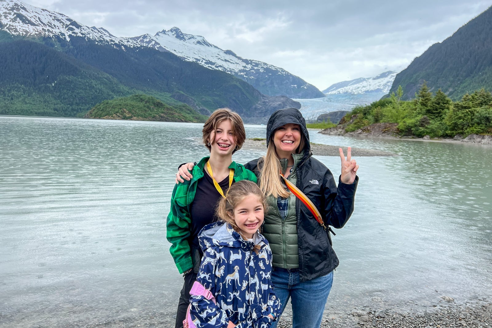 A mother and her two daughters standing in front of a river in Alaska
