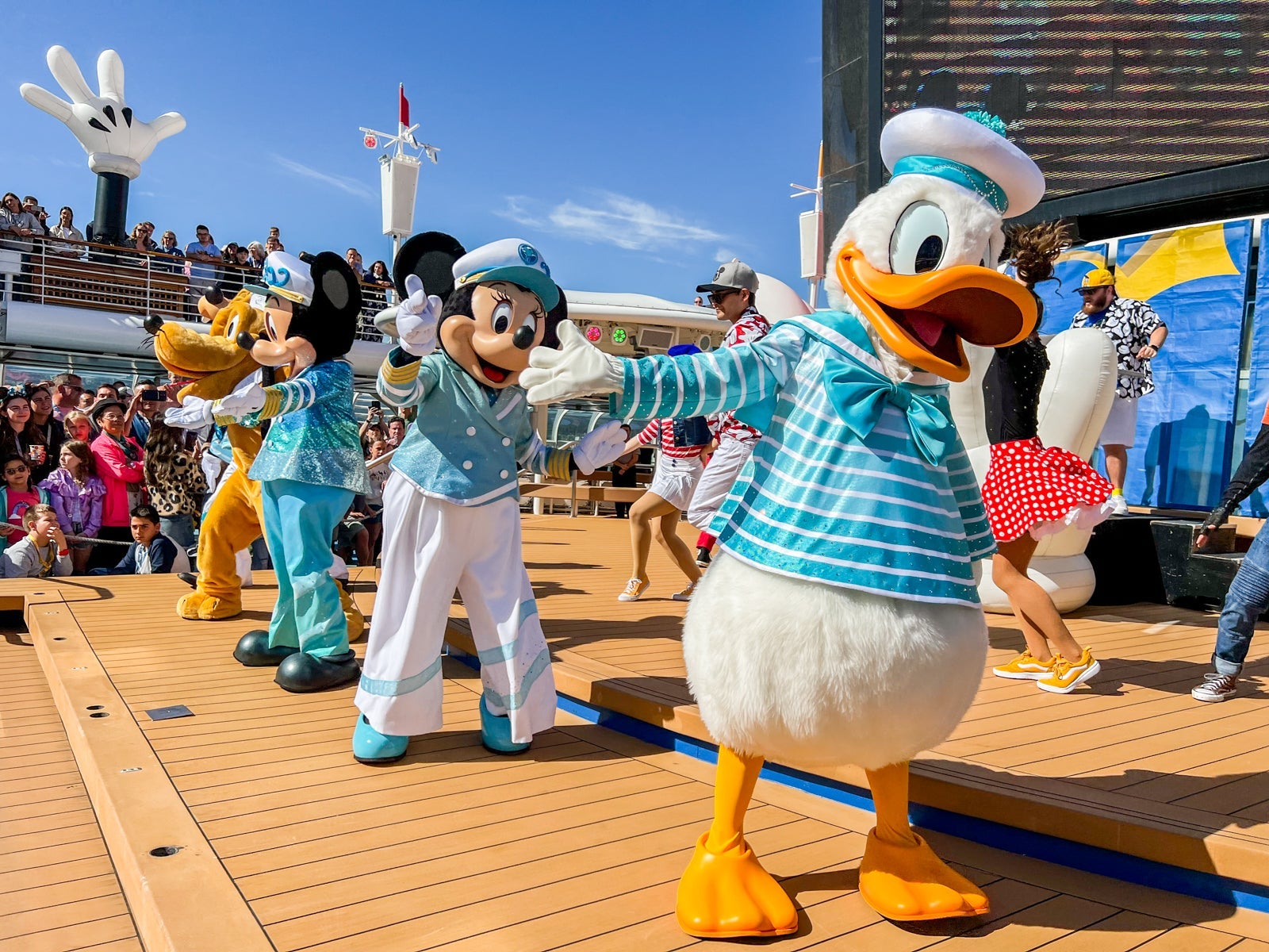 Donald Duck, Minnie Mouse, Mickey Mouse and Pluto dance on a cruise ship sun deck