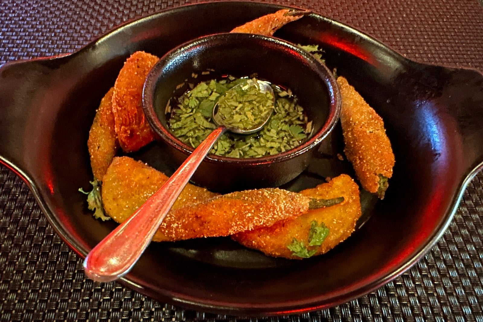 Fried okra on a round dish with dipping sauce in the middle