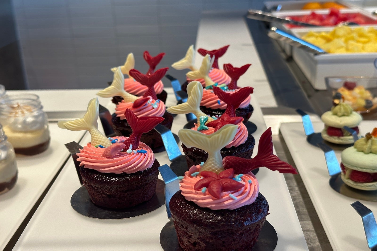 Chocolate cupcakes with pink frosting and candy mermaid tails
