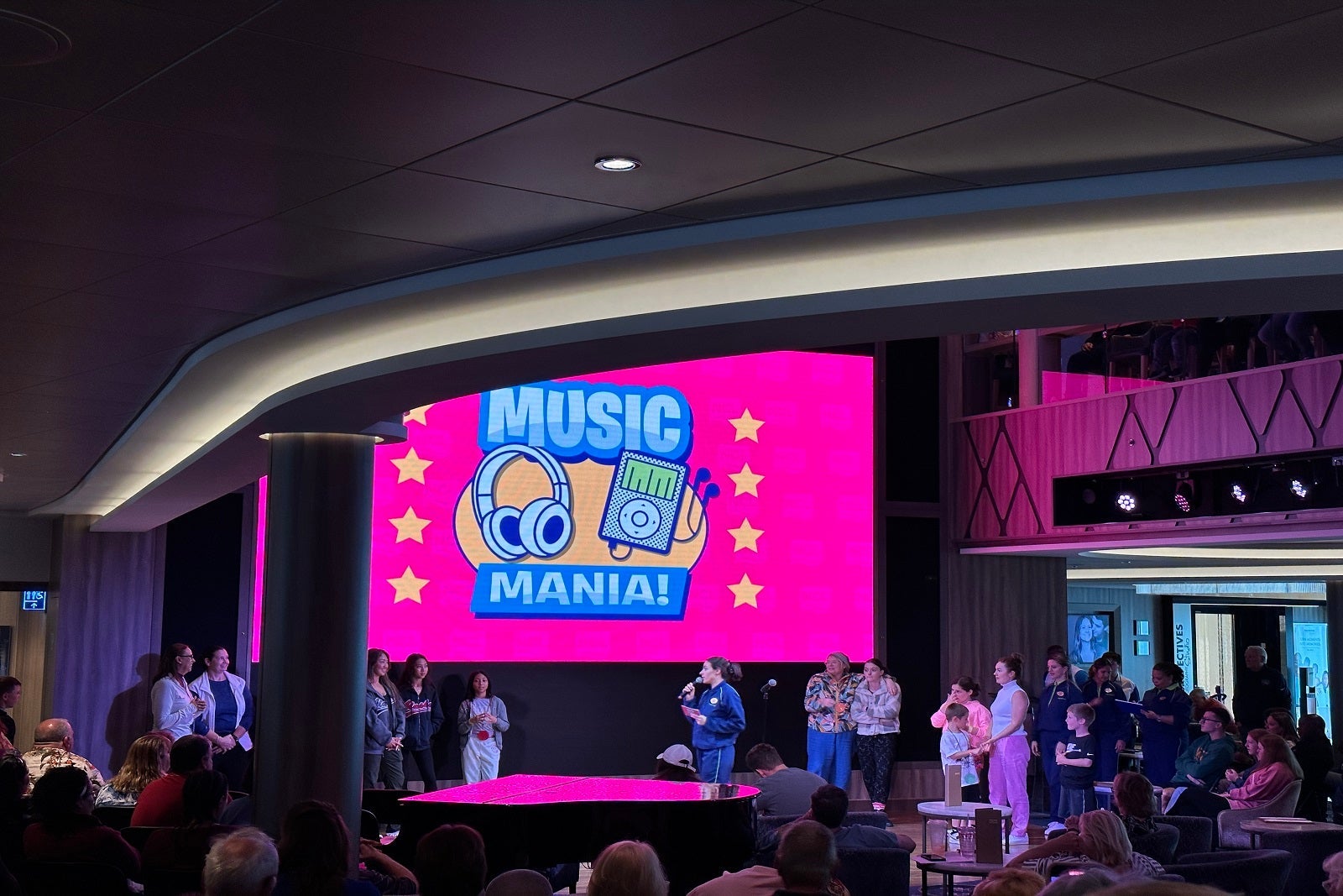 An atrium screen with the words "Music Mania" on it