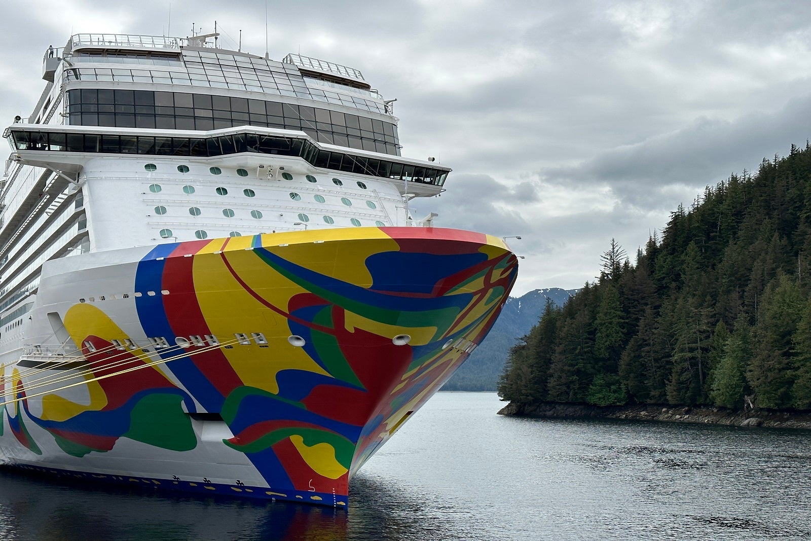 A cruise ship with a colorful hull docked in Ketchikan, Alaska