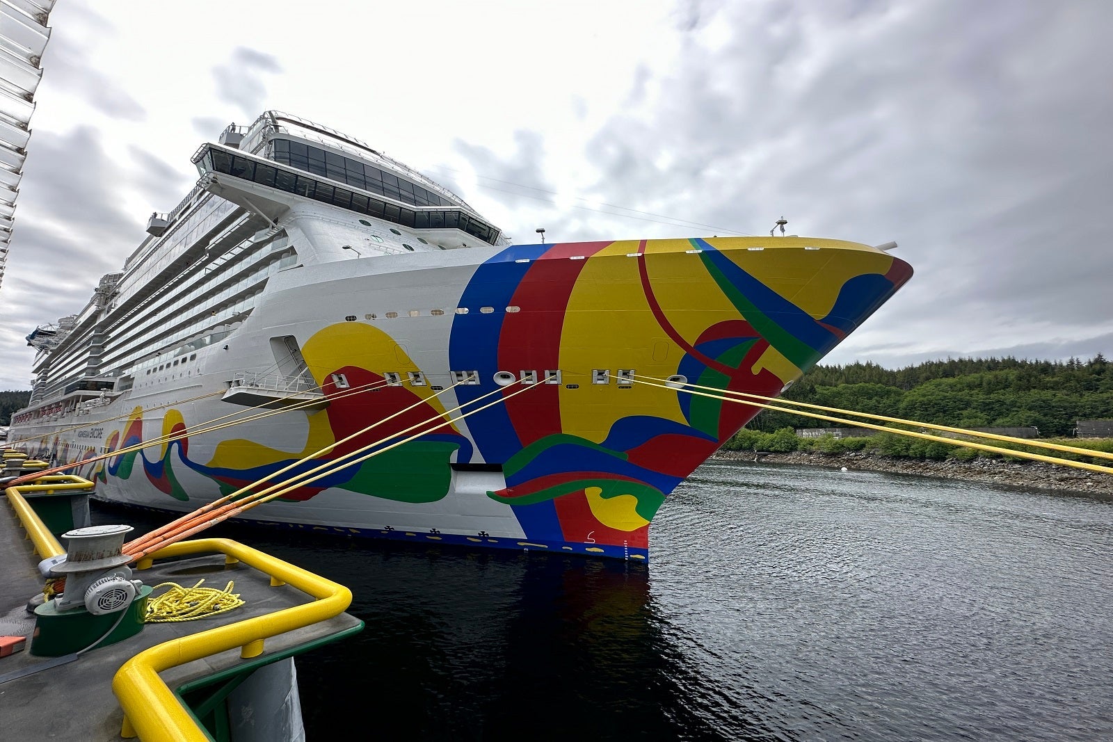 A close-up of the front of a cruise ship's starboard side hull art, which features red, blue, yellow and green squiggles