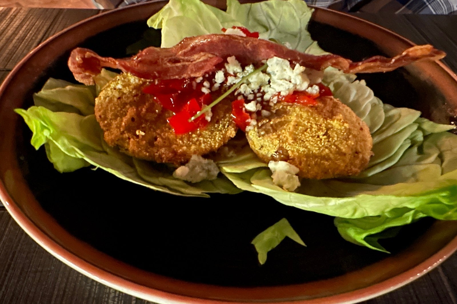 Fried green tomatoes on a bed of lettuce on a plate