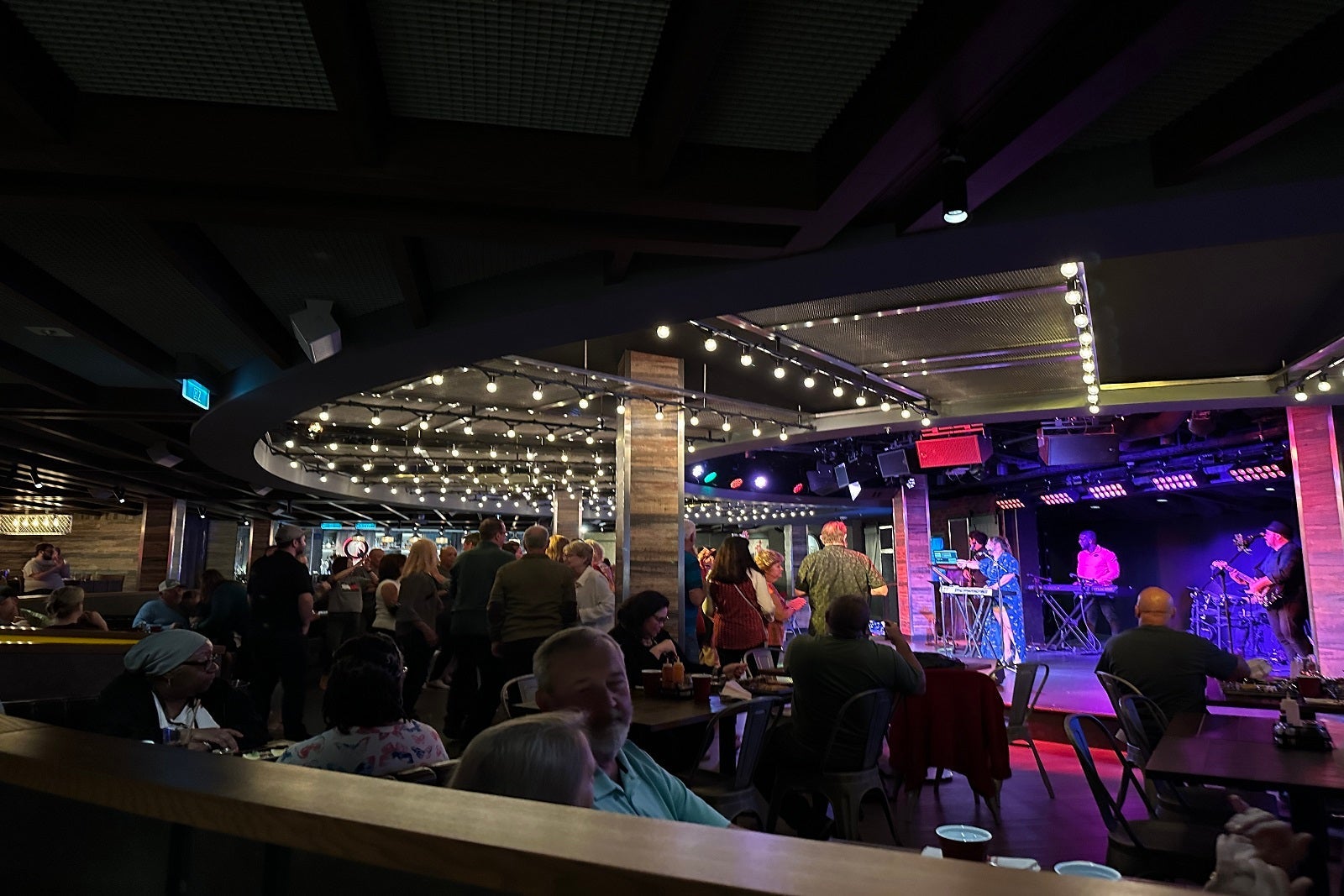 A crowd of diners at a cruise ship restaurant enjoying entertainment