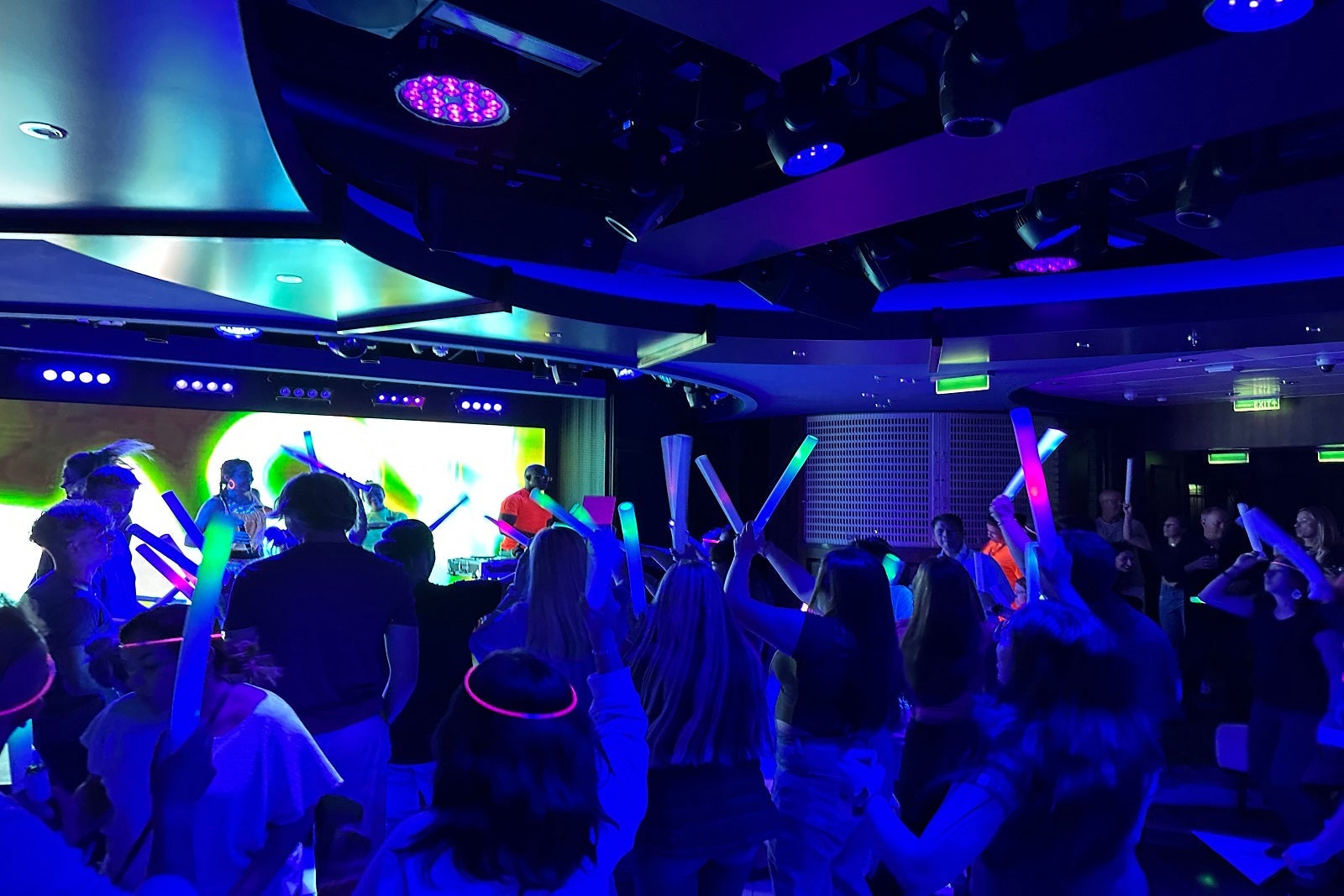 A group of cruise passengers with glow sticks at an after-hours party in the club