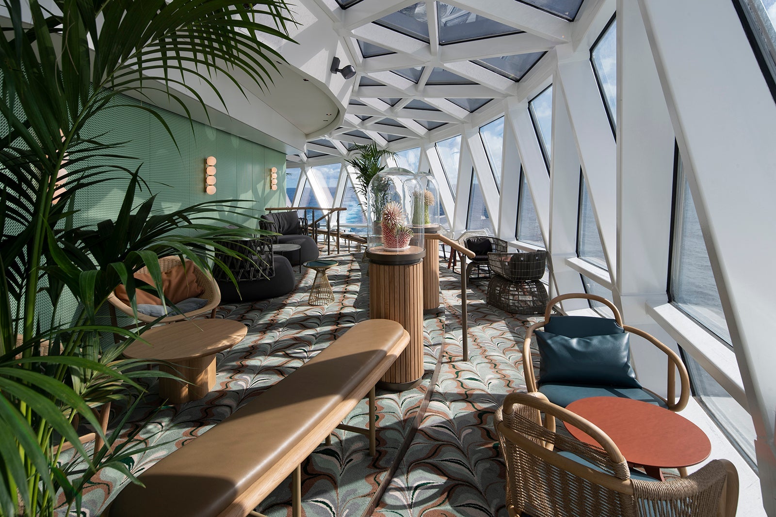 Seating areas and floor-to-ceiling windows in Eden Lounge on Celebrity Edge. 