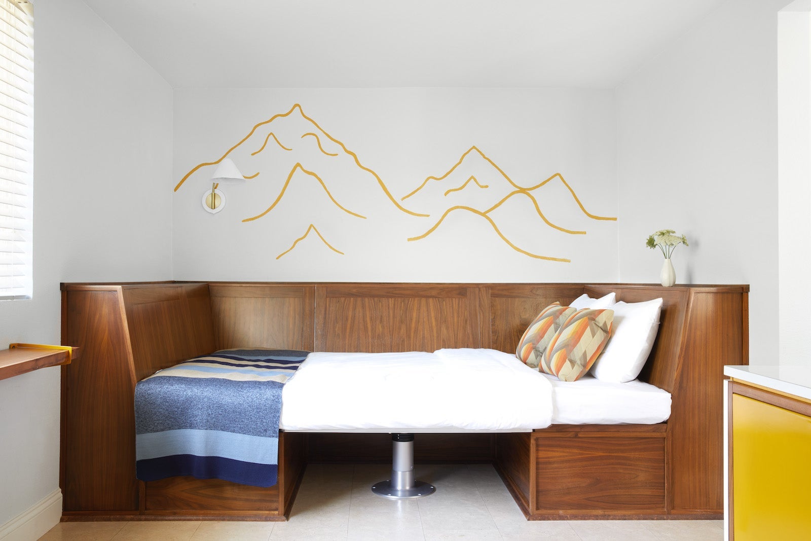 mountain image on wall above bed in converted wooden-table