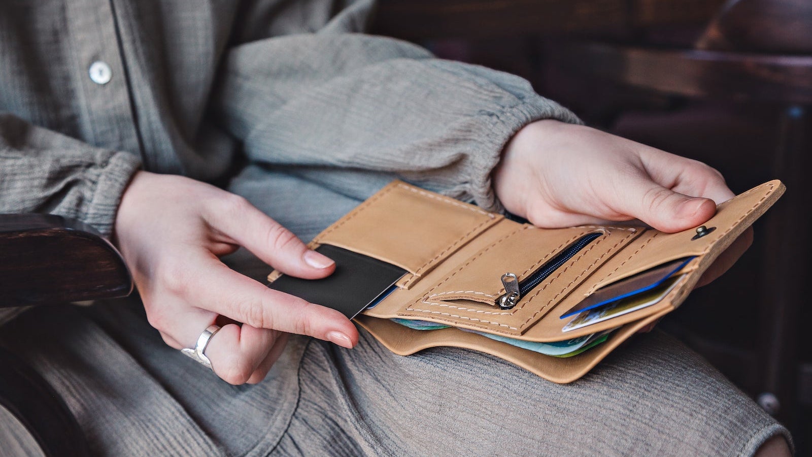 The woman takes out a credit card from his wallet