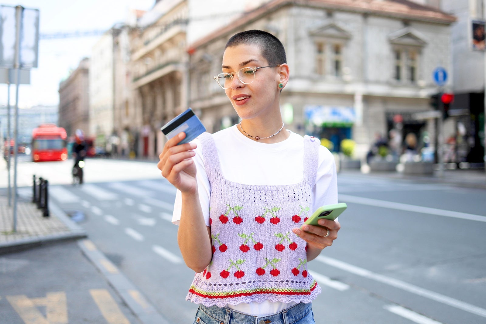 Person holding a credit card and phone on the street