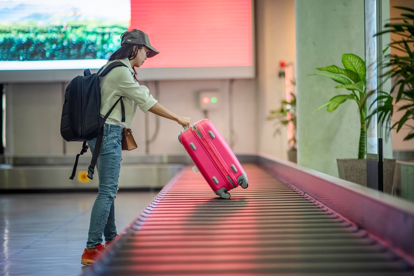 Woman collecting luggage at baggage claim