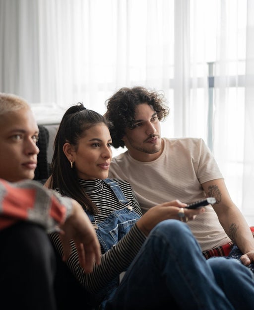 Friends watching tv together at home