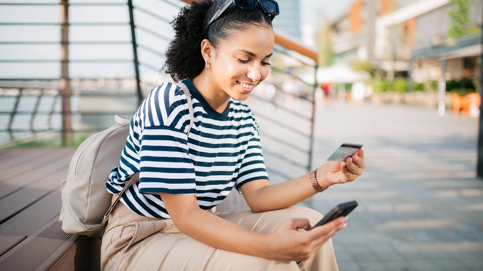 Happy young woman shopping online using a smart phone