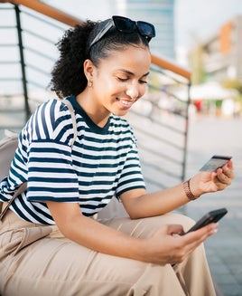 Happy young woman shopping online using a smart phone