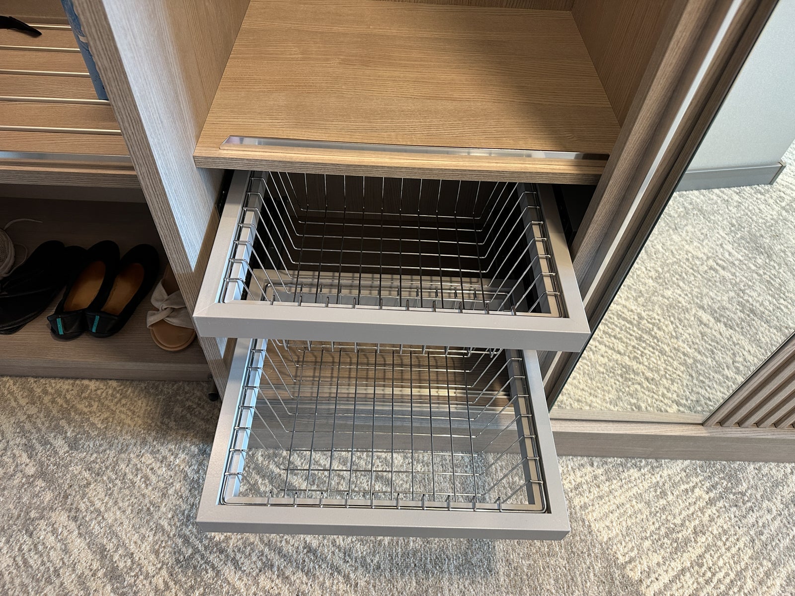 A pair of wire draweres in the closet in a cruise ship cabin